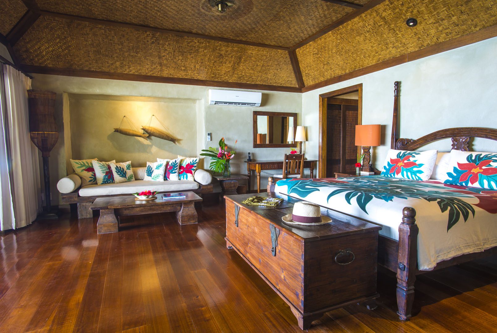 A side view of the Premium Beachfront Bungalow bedroom showcasing the attributes in the room and also features the beautiful cabana-bamboo-matting ceiling