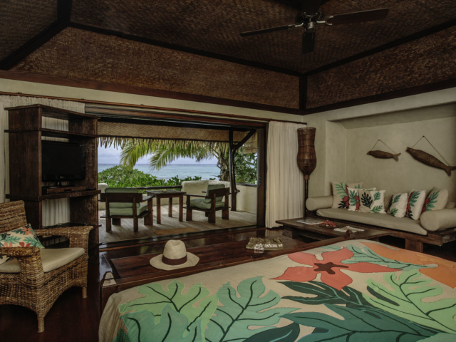 A beautiful interior image of the Premium Beachfront Bungalow bedroom overlooking the private balcony and the lagoon