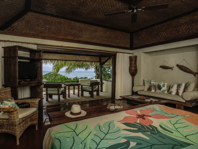 A beautiful interior image of the Premium Beachfront Bungalow bedroom overlooking the private balcony and the lagoon