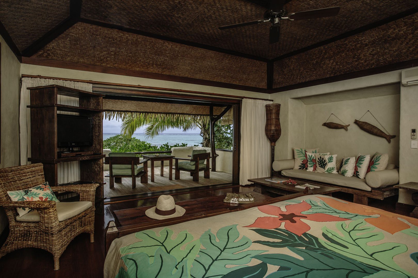 A beautiful interior image of the Premium Beachfront Bungalow bedroom overlooking the private balcony and the lagoon