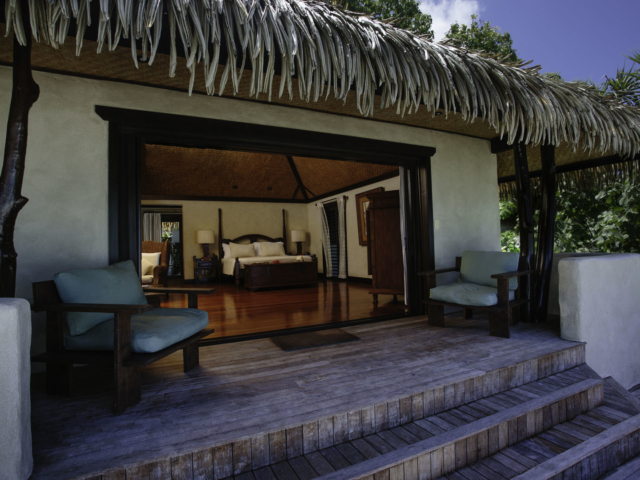 A beautiful front view of the Ultimate Beachfront Bungalow private deck and bedroom with lightings to enhance the bedroom decor and layout