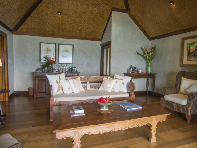 A view of the Ultimate Beachfront Villa Living room showcasing the traditional wood carvings on lounges and interior décor