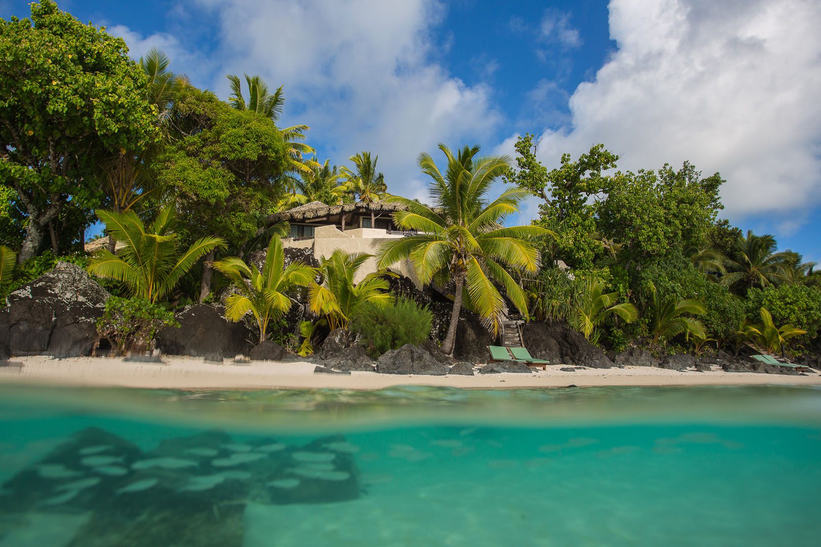 View of the Ultimate Beachfront Villa and lush tropical gardens, overlooking the blue lagoon