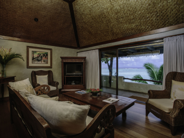 Interior of the modern Ultimate Beachfront Villa Living area with large sliding doors opening out onto the deck overlooking the lagoon