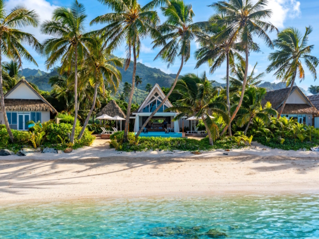 Aerial view of Little Polynesian Resort beachfront bungalows and lagoon in Rarotonga