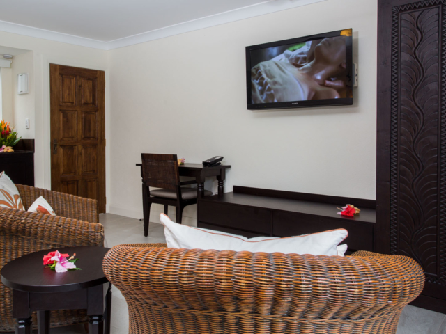 Image of the Standard Family Room lounge featuring a flat mounted TV screen and a customized wooden wardrobe design
