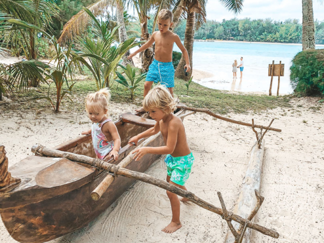 Children of Resort guests playing in the Warrior Canoe by the beach
