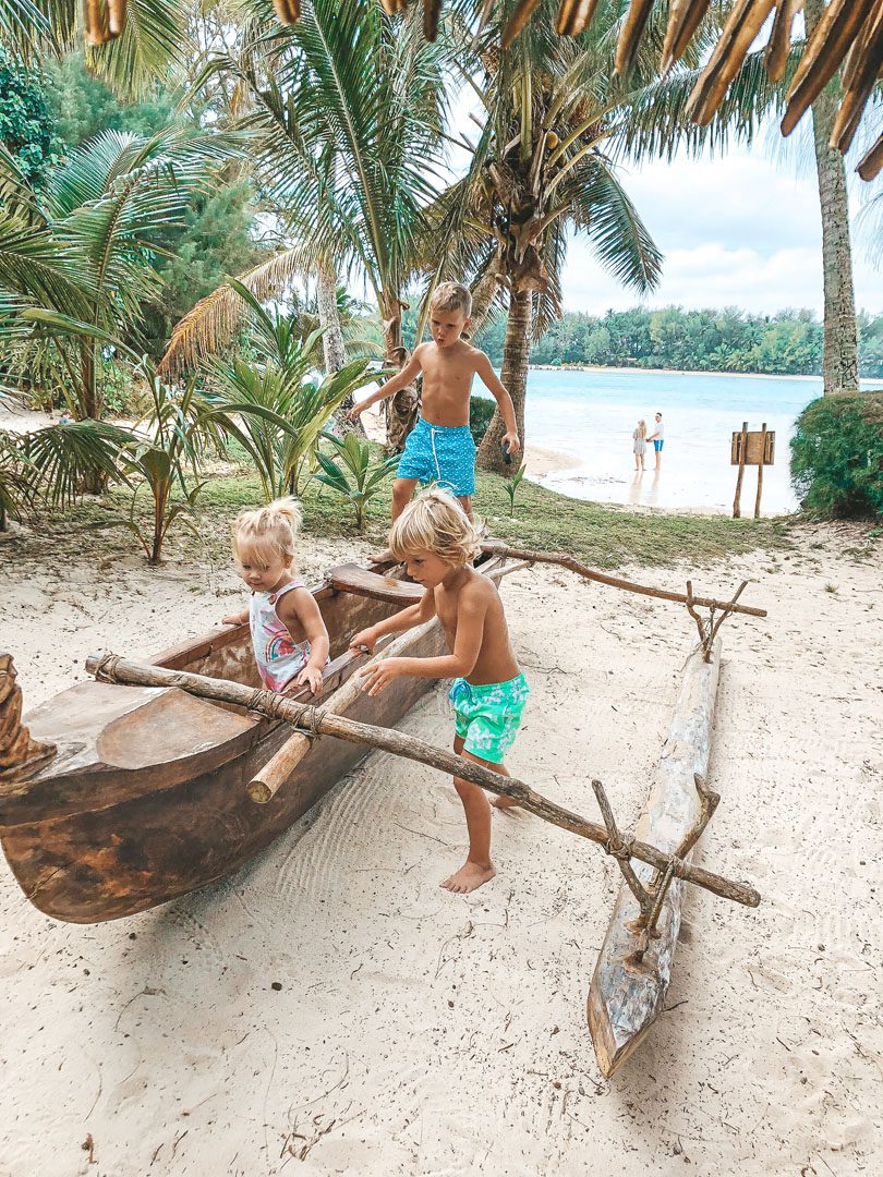 Children of Resort guests playing in the Warrior Canoe by the beach