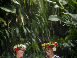 Image of hardworking Resort Attendants happily performing daily routines wearing tropical head eis or tiaras with flowers behind their ear that symbolizes peace and happiness