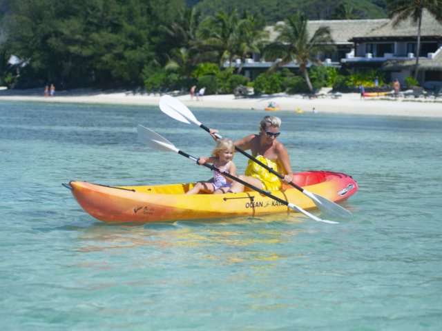 Image of mother and daughter happily kayaking in the Muri Lagoon, in front of the resort