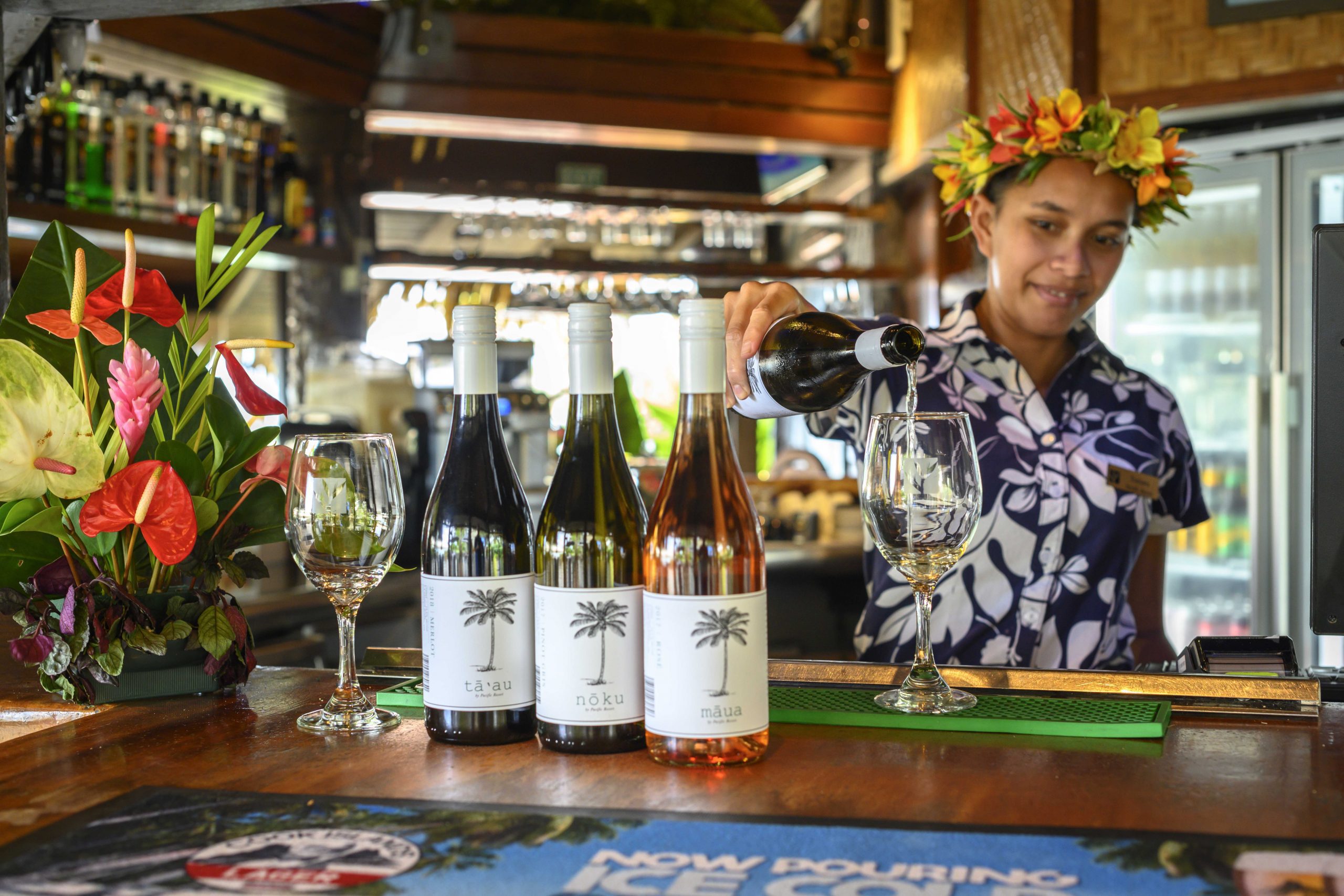 Resort bar attendant showcasing her wine-pouring skills and the variety of wine options available at the bar