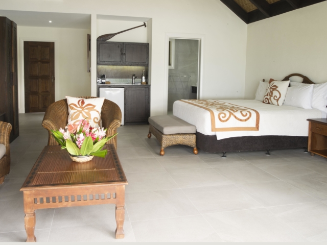 Interior image of the newly refurbished Premium Beachfront Suite showcasing the comfortable super king sized bed and spacious open-plan layout that allows the cool sea breeze to sway in