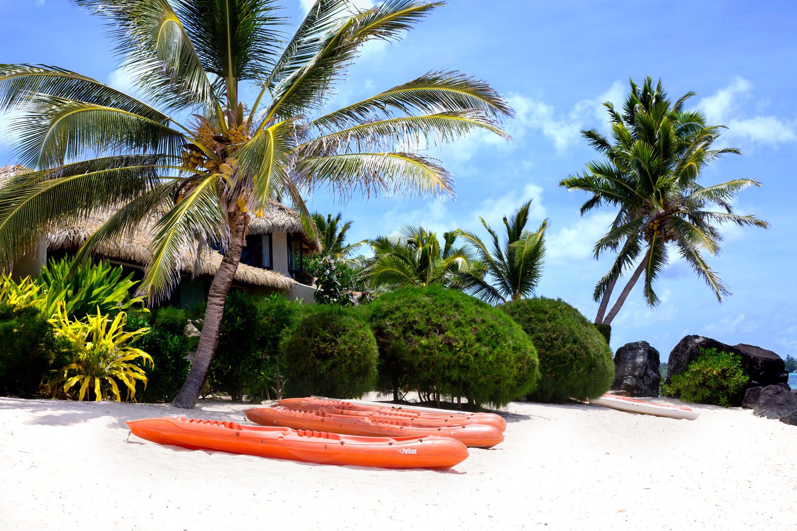view of te manava villas from the white sandy beach with Kayaks lined up along the beach ready for guests