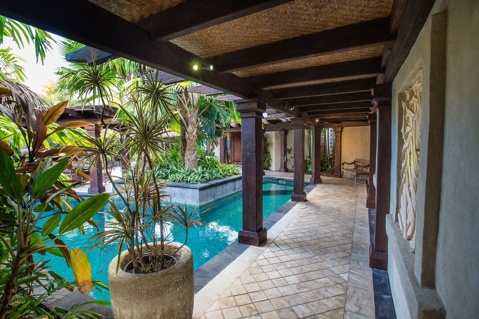 View of the modern Presidential Beachfront Villa Pool surrounded by lush tropical gardens