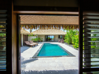 View from the inside of the Ultimate beachfront villa, leading out to the pool area with a lagoon view