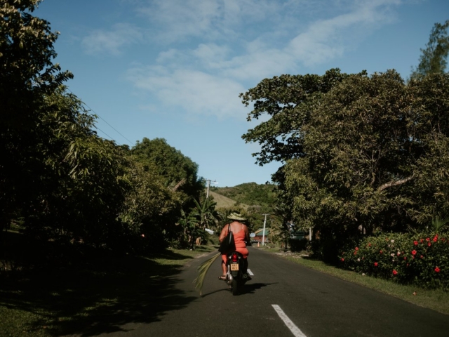 Local driving in Aitutaki among lush greenery