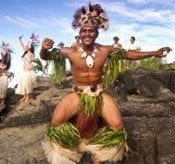 Island warrior dancing with island troupe in background