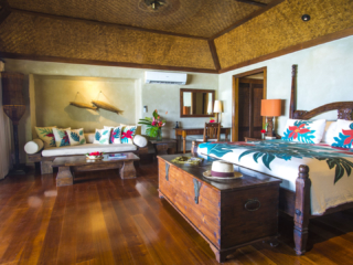 A side view of the Premium Beachfront Bungalow bedroom showcasing the attributes in the room and also features the beautiful cabana-bamboo-matting ceiling