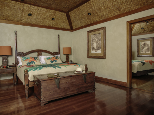 A beautiful view of the Premium Beachfront Bungalow one-bedroom featuring the various art designs on the head-bed, lamps and pictures on the wall