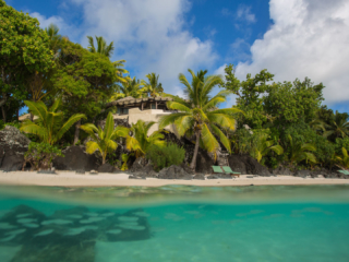 View of the Ultimate Beachfront Villa and lush tropical gardens, overlooking the blue lagoon