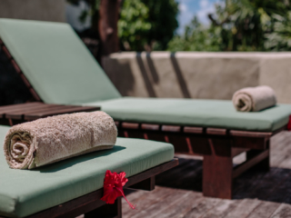 Sun Loungers with tropical flowers and fresh towels laid out in front of the Ultimate Beachfront Villa