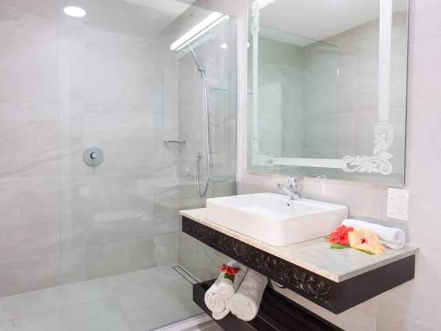 Image of the Standard Room bathroom featuring complimentary supply of bath towels beautifully rolled up in the vanity area