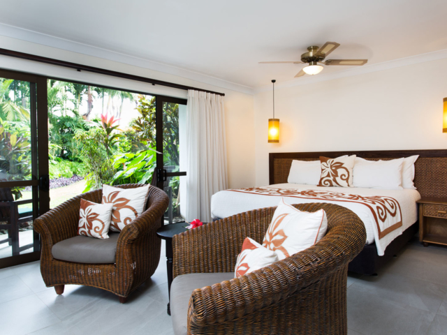 A neatly arranged Super sized king bed in the Studio Room showcasing the matching linen and cushion covers in a spacious room