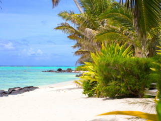 View of the beautiful white sandy beach and blue lagoon located in front of Te Manava