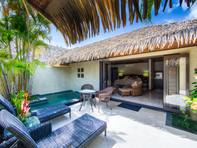 View from the tiled patio area with luxurious outdoor settings and private pool, looking into the Pool villa suite bedroom
