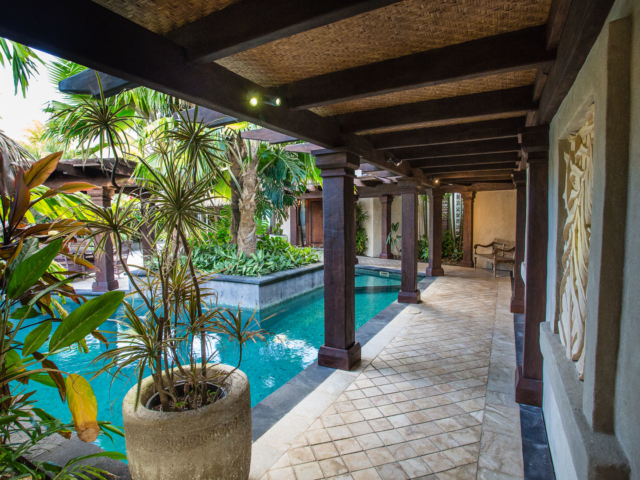 View of the modern Presidential Beachfront Villa Pool surrounded by lush tropical gardens