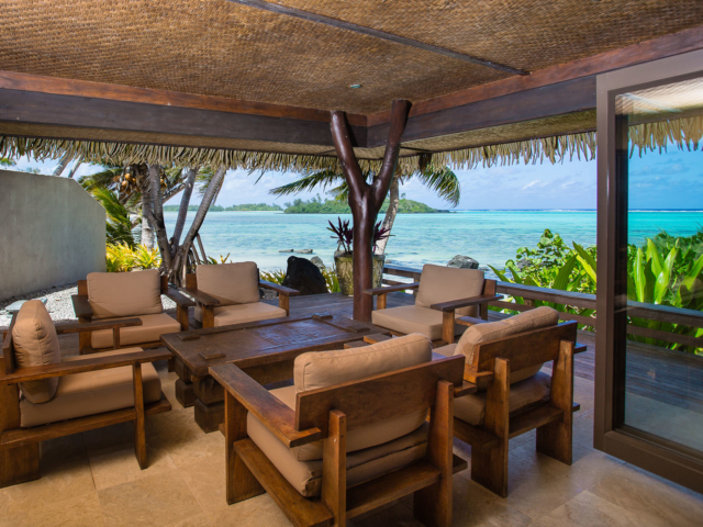 Large open wooden decking in the Presidential villa, modern furniture displayed overlooking the lagoon