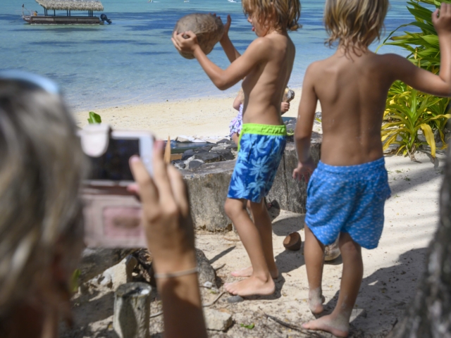 Image of two young boys demonstrating their coconut husking skills learnt from the Resort’s activities attendants