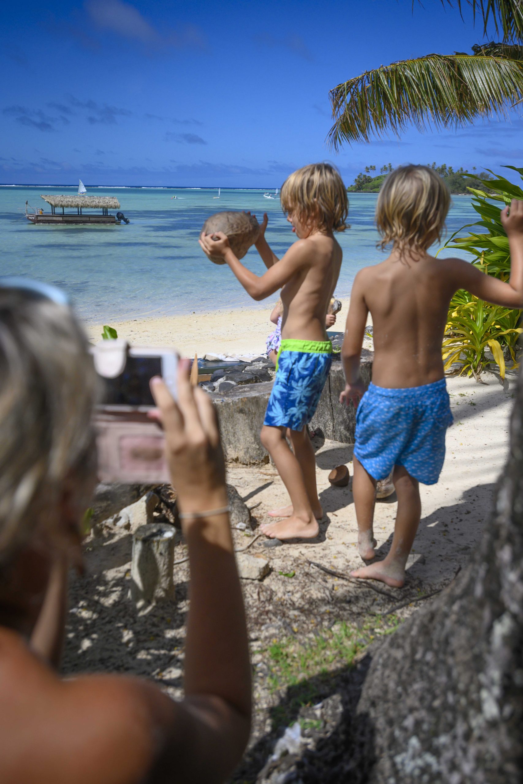 Image of two young boys demonstrating their coconut husking skills learnt from the Resort’s activities attendants