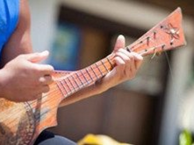 Beach hut attendant playing the ukulele