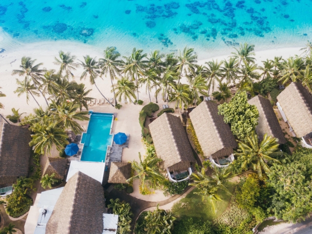 Aerial view of Little Polynesian Resort and Titikaveka Lagoon from the water looking towards the property