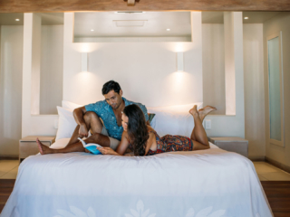 A couple relaxing in their room reading a book