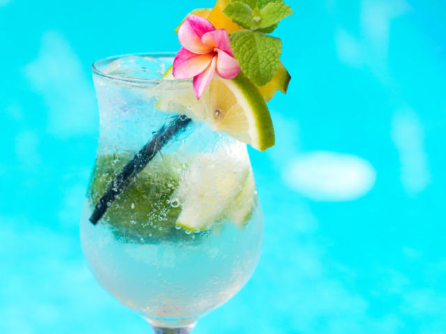 A colourful garnished cocktail by the pool