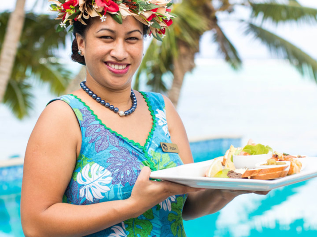 Friendly Waitress serving a tropical platter overlooking our infinity pool