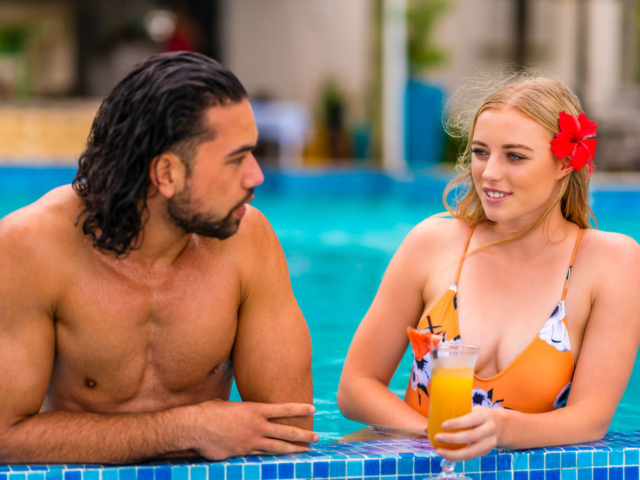 A couple enjoying a cocktail in the pool