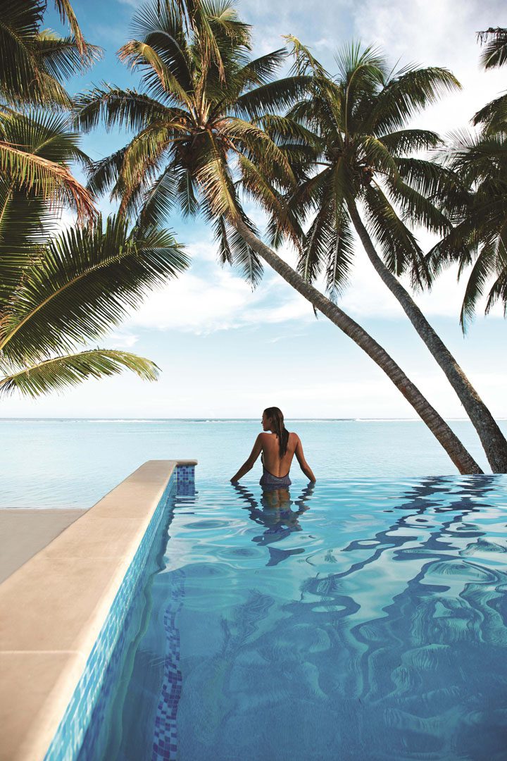 A woman taking in the breathtaking views of the beach from the infinity pool