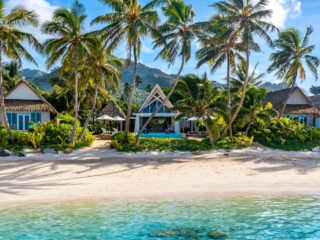Aerial view of Little Polynesian Resort beachfront bungalows and lagoon in Rarotonga